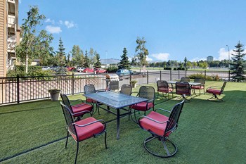 An outdoor area for residents with tables and chairs with a grill Property Image